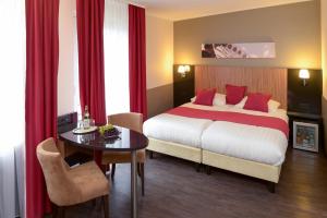 慕尼黑慕尼黑市酒店的酒店客房配有一张床铺和一张桌子。