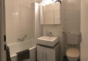 慕尼黑Apartment Schwabing/Olympic Park/BMW的浴室配有盥洗盆、卫生间和浴缸。