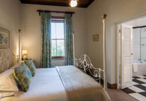 MatjiesfonteinLord Milner Hotel的一间卧室设有一张大床和一个窗户。