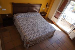 加苏莱斯堡拉帕尔摩萨酒店的一间卧室配有一张带木制床头板的床和窗户。