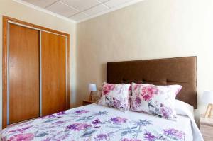 托雷维耶哈Bungalow frente al mar的一间卧室配有一张带粉色和紫色枕头的床