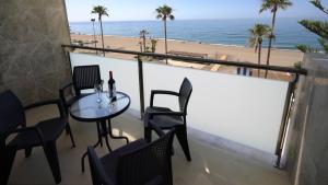 莫切As Apartamentos Turisticos的一个带桌椅和海滩的阳台