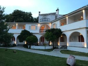 特劳洛斯吉娜别墅酒店的一座带庭院的大型白色房屋