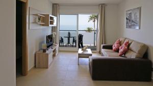 莫切As Apartamentos Turisticos的带沙发的客厅,享有海景