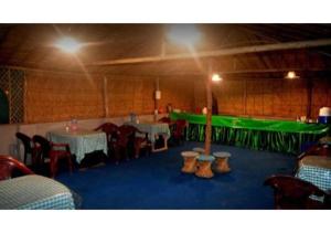 ShivpuriGanga TreePie Riverside Camps的一间带桌椅和绿色墙壁的餐厅