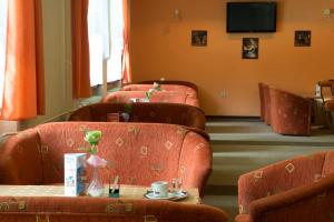 利托斯基简Hotel SOREA ĎUMBIER的一间备有橙色椅子和桌子的等候室