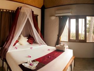 涛岛阿南凯拉别墅度假村的一间卧室配有带鲜花的天蓬床