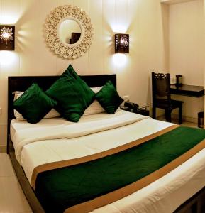 哈里瓦拉卡萨酒店的一间卧室配有一张带绿色枕头和镜子的床