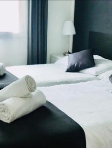 SomeoDonjon B&B e Ristorante的客房内的两张白色床和毛巾