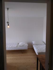 Brod nad DyjíKůlna的配有白色墙壁和木地板的客房内的两张床