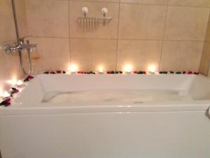洛帕Apartments Mestrovic的浴室内设有带蜡烛的白色浴缸