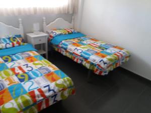 La Venteta2º Linea de Playa, Barcelona的两张睡床彼此相邻,位于一个房间里