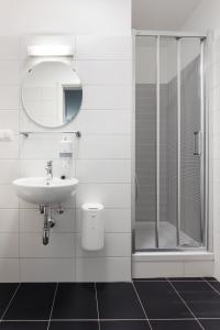 因斯布鲁克旱獭旅馆的白色的浴室设有水槽和淋浴。
