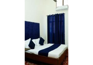 钱德加尔Inderlok Hotel的一间卧室配有蓝色窗帘的床