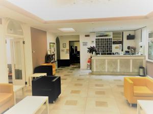利多迪耶索罗滨海酒店的大厅,大厅设有黄色椅子和柜台