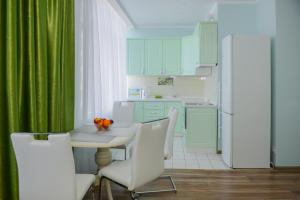 敖德萨Sea View Odessa的厨房配有绿色窗帘和桌椅