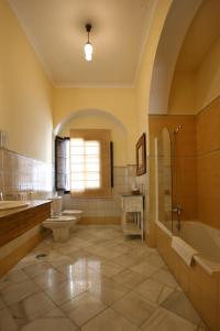桑卢卡尔-德巴拉梅达帕拉西奥酒店的浴室配有2个盥洗盆、卫生间和浴缸。