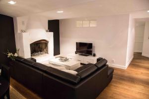 斯德哥尔摩Executive Living Östermalm Suite的客厅配有黑色沙发和壁炉