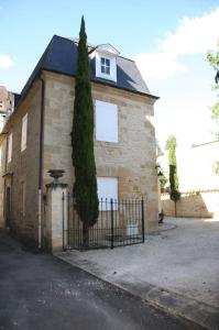 萨尔拉拉卡内达Les Chambres d'Hotes chez Alisa et Daniel的前面有树的砖房