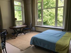 WesterveldeDe Jufferen Lunsingh的卧室配有床、桌子和窗户。