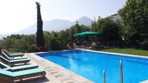 托雷斯卡瓦尼亚斯艾玛吉那酒店的一个带椅子和遮阳伞的游泳池以及山脉