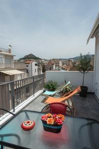 雅典Acropolis Monastiraki Newly Renovated Apartment的阳台上的一张桌子上放着一碗鲜花
