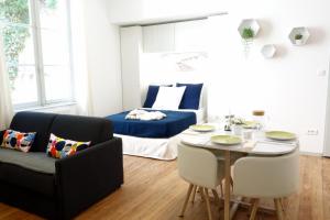 阿尔勒Arles Holiday - Le Studio Chic的客厅配有桌子和床。