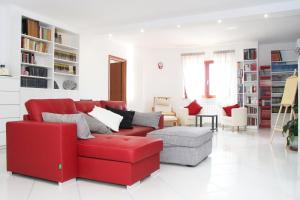 泰卡斯MarArte B&B的客厅里设有一张红色的沙发和一把椅子