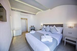 切法卢Ossuna Bay Hotel Boutique的卧室配有带毛巾的大型白色床
