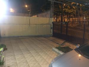 坎皮纳斯Casa Familiar em Campinas com 2 Quartos, 1 banheiro, 1 vaga para carro的夜间有栅栏的空停车位