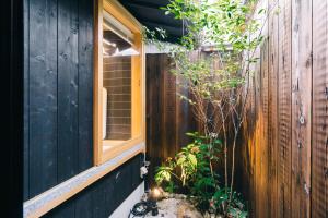 京都Miro Hachijo Genmachi Tei的木栅栏,带窗户和植物