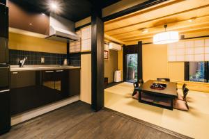 京都Miro Hachijo Genmachi Tei的一间带桌子的客厅和一间厨房