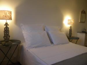 博讷Les chanceliers Duplex的配有白色枕头和两盏灯的白色床