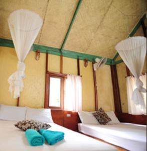 波特尔海滩博透海滩微笑简易别墅酒店的客房设有两张带蓝色枕头的床。