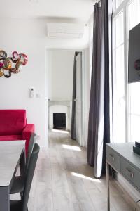 耶尔Aux Iles d'Or的客厅设有红色的沙发和壁炉