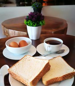 梳邦再也我的Sj酒店 的桌子,上面放着烤面包,鸡蛋,还有一杯咖啡
