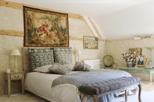 La Chapelle-MontligeonLe bourgis的卧室配有一张床,墙上挂有绘画作品