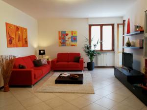 卡利亚里Cagliari Family Apartment的客厅配有2张红色沙发和电视