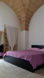 加利亚诺德尔卡波Palazzino in centro storico的一间卧室,在房间内配有一张紫色的床