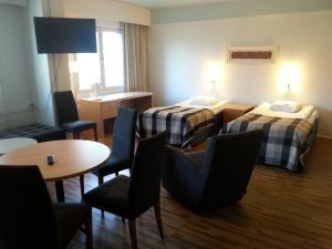 帕尔加斯石灰海滩酒店的酒店客房带两张床和一张桌子以及椅子。
