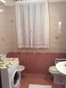 杜伊诺Casa Vacanze All'Orizzonte Duino的一间带卫生间和洗衣机的浴室