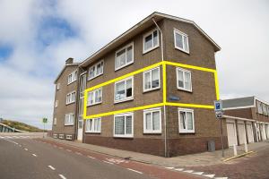 滨海卡特韦克kustappartementenkatwijk的一条棕色砖砌的街道上,有白色的窗户