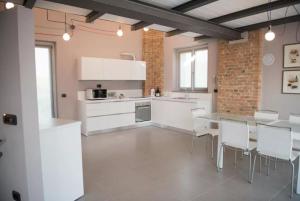 拉莫拉Cascina Goretta Agriturismo的厨房配有白色橱柜和桌椅