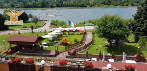 布劳巴赫莱茵贝拉维斯塔酒店的湖畔公园,公园里设有桌子和遮阳伞