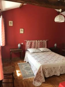 Vernoux-en-Gâtinela raymondiere的卧室配有红色墙壁内的一张床