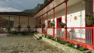 萨兰托La Cabaña Ecohotel - Valle del Cocora的庭院里一座红色装饰和鲜花的建筑