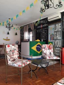 巴乌鲁Casa Beatles Hostel Bauru的一间房间,配有两把椅子和一张桌子,上面有旗帜