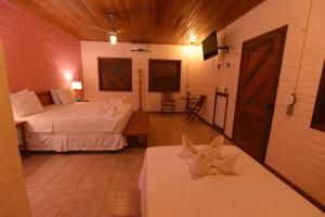 巴雷里尼亚斯普雷格伊萨斯港度假酒店的一间带两张床的卧室和一间带两张桌子的房间