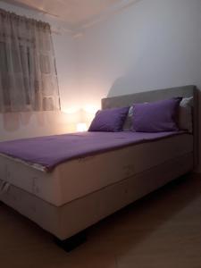 斯韦蒂·斯特凡Porodični的一张带紫色枕头的床