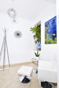 卡普里La Perla Blu的白色的客厅配有白色的沙发和三脚架